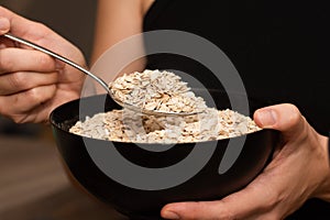 Serving Oats with a Spoon. Scooping oats from a bowl with a metal spoon