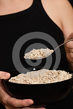 Serving Oats with a Spoon. Scooping oats from a bowl with a metal spoon