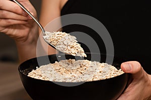 Serving Oats with a Spoon. Scooping oats from a bowl with a metal spoon