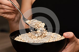 Serving Oats with a Spoon. Scooping oats from a bowl with a metal spoon