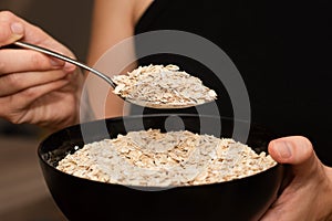 Serving Oats with a Spoon. Scooping oats from a bowl with a metal spoon