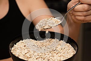 Serving Oats with a Spoon. Scooping oats from a bowl with a metal spoon