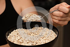 Serving Oats with a Spoon. Scooping oats from a bowl with a metal spoon