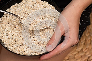 Serving Oats with a Spoon. Scooping oats from a bowl with a metal spoon