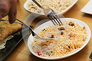 Serving pilau rice from a white tray