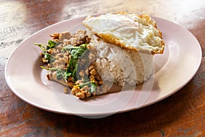 Serving of Prad Ka Pao, popular Thai steet food made up of fried minced pork with basil and fried egg with rice