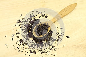 Serving of shredded basil leaves in wooden spoon