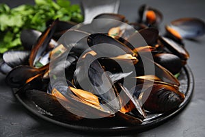 Serving slate board with cooked mussels on table, closeup