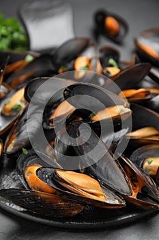 Serving slate board with cooked mussels on table, closeup