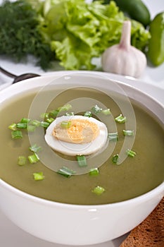 Serving of spinach cream soup with vegetables
