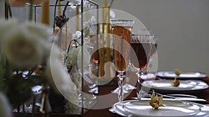 Serving table prepared for event celebration, party or wedding. Footage. Close up of white plates, glasses with