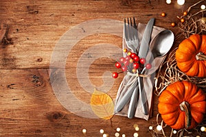 Serving for Thanksgiving dinner with napkin, cutlery and pumpkins top view. Autumn table setting