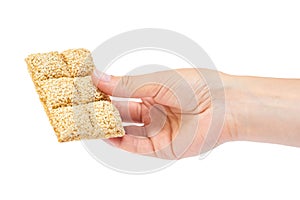 Sesame brittles brick in hand Isolated on white background.