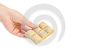 sesame brittles brick in hand Isolated on white background. copy space, template