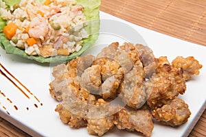 Sesame chicken dish and chopsticks on bamboo placemat photo