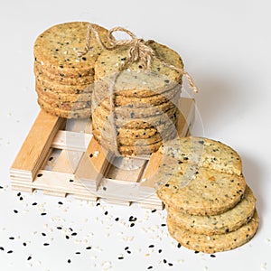 Sesame cookies pile with rustic twine isolated on white background. Square picture