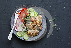 Sesame crust baked chicken breast and fresh vegetables. Baked chicken and tomatoes, cucumbers, peppers, radishes, micro greens sal