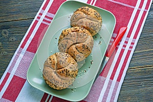 Sesame Kaiser Rolls, round bread rolls on plate