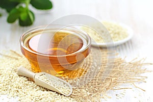 Sesame oil in glass and seeds on the table