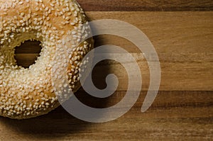 Sesame seed bagel on wood