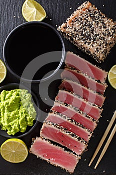 Sesame Seed Crusted Seared Tuna served with wasabi and sauce closeup. Top view vertical