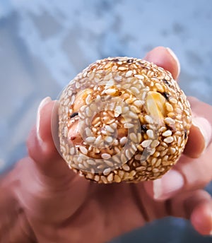 Sesame seeds and peanut jaggery ball in hand