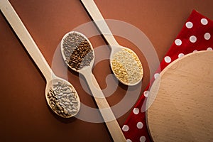 Sesame, sunflower seeds and linseed on a wooden spoon on the table