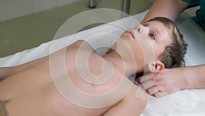 Session of craniosacral therapy, cure of teen boy's neck by a doctor therapist.