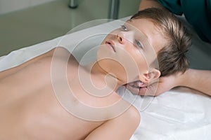 Session of craniosacral therapy, cure of teen boy& x27;s neck by a doctor therapist.