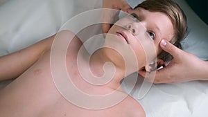 Session of craniosacral therapy, cure of teen boy's neck by a doctor therapist.