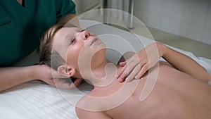 Session of craniosacral therapy, cure of teen boy's neck by a doctor therapist.