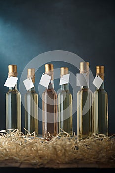 Set of 250 ml bottles of white and pink wine with blank labels. Wooden shavings below. Wines assortment. Copy space, vertical shot