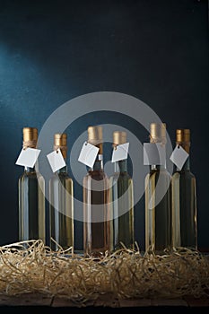 Set of 250 ml bottles of white and pink wine with blank labels. Wooden shavings below. Wines assortment. Copy space, vertical shot