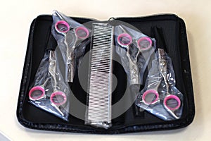 a set of 4 pairs of scissors and a comb for grooming dogs and cats