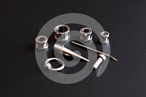 Set of accessories for piercing on a dark background
