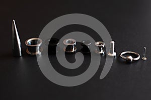Set of accessories for piercing on a dark background