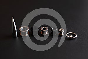 Set of accessories for piercing on a dark background