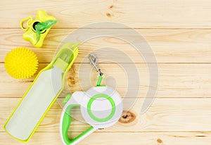 Set of accessories for walking your dog: leash, bottle for water, dog cleaning bags on wooden background. Pet care and training