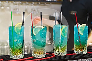 Set of alcohol cocktails in glasses, served in bar, waiting for visitors of a club, shallow dof