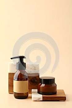 Set of amber glass cosmetic bottle and jar of moisturizer on podium. Natural SPA beauty products design, skin care concept