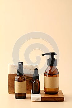 Set of amber glass cosmetic bottles on pedestals. Natural SPA beauty products branding