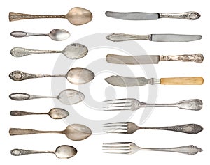 A set of antique fine silverware. Vintage spoons, forks and knifes isolated on a white background.