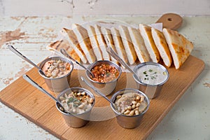 Set of appetizers: hummus, muhammara, tirokafteri, Greek cacik