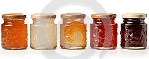 Set of assorted jams in glass bottles on white background. Sweet jams in row
