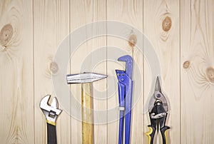 A set of assorted work carpentry and locksmith tools on a light wooden background with copy space
