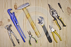 A set of assorted work carpentry and locksmith tools on a light wooden background with copy space