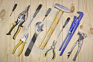 A set of assorted work carpentry and locksmith tools on a light wooden background with copy space