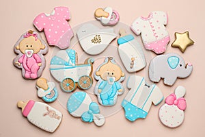 Set of baby shower cookies on light pink background, flat lay