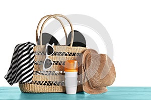 Set of beach accessories on blue table, white background