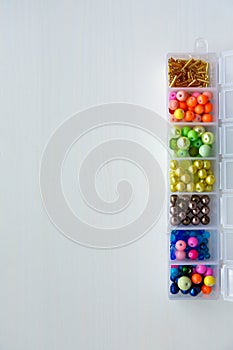A set of beads of different colors and shapes in a container
